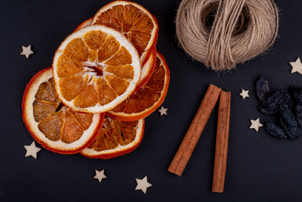 side-view-of-dried-orange-slices-with-cinnamon-sticks-arranged-on-black-background.png
